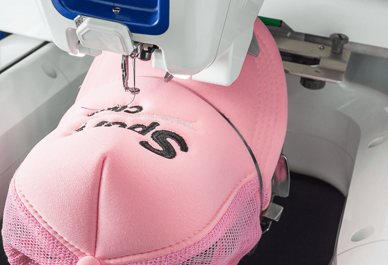 Embroidery machine personalising a branded cap