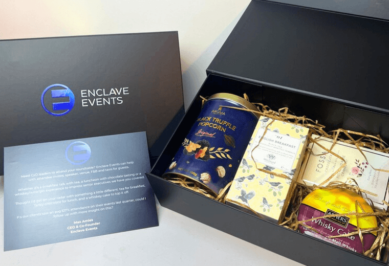 Enclave Events gift box with branded packaging, wine, gourmet snacks, and outreach letter